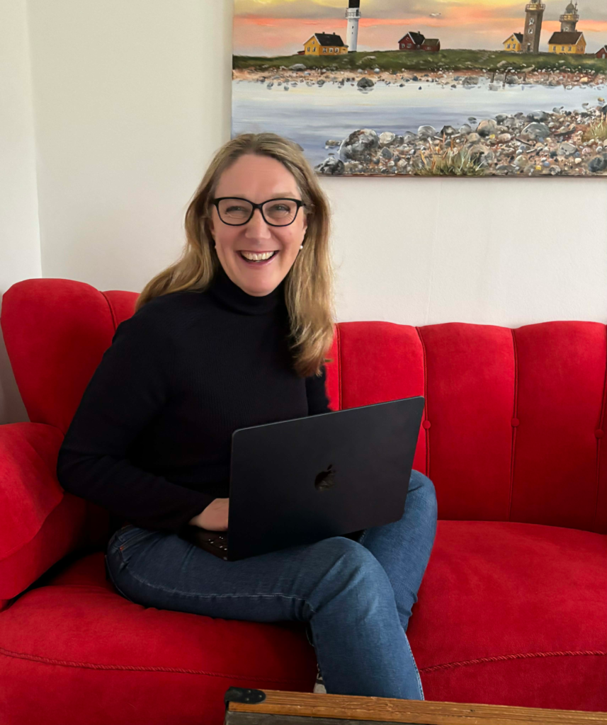 Karin sitting in read sofa with laptop