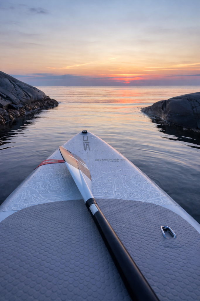 The tip of a SUP board and a calm see symbolizing simplicity